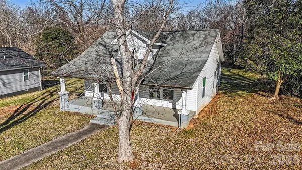 an aerial view of house with yard and mountain view in back
