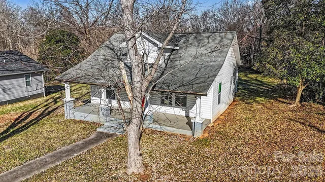 an aerial view of house with yard and mountain view in back