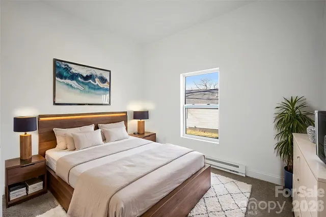 a bedroom with a bed and a potted plant
