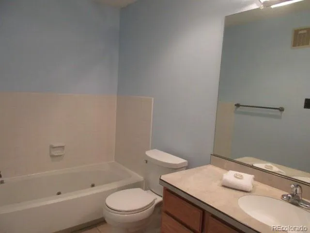 a bathroom with a granite countertop sink a toilet and bathtub