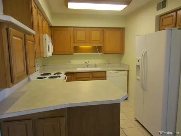 a view of a kitchen with stainless steel appliances wooden cabinets and a refrigerator