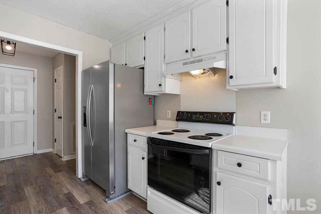 7929 Flower Hill Road Middlesex, NC 27557 - Photo 5 of 28 a kitchen with stainless steel appliances granite countertop a stove a refrigerator and a white cabinets