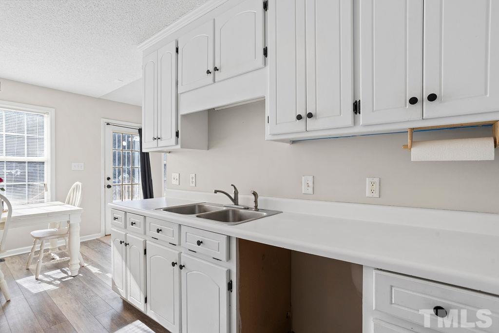 7929 Flower Hill Road Middlesex, NC 27557 - Photo 7 of 28 a kitchen with stainless steel appliances granite countertop white cabinets sink and dishwasher