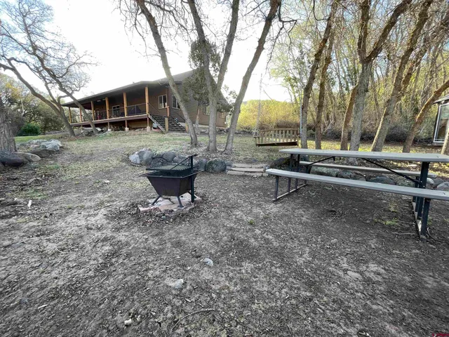 a view of a house with backyard and sitting area