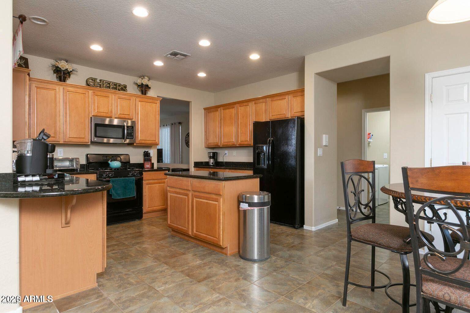 2023 West Shackleton Drive Phoenix, AZ 85086 - Photo 5 of 11 a kitchen with stainless steel appliances granite countertop a refrigerator a stove top oven and a sink with granite countertops
