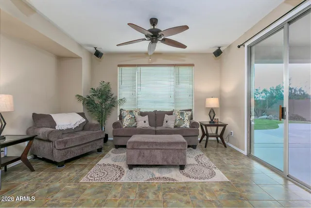 a living room with furniture and a large window with garden view