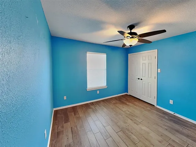 a view of room with hardwood floor and ceiling fan