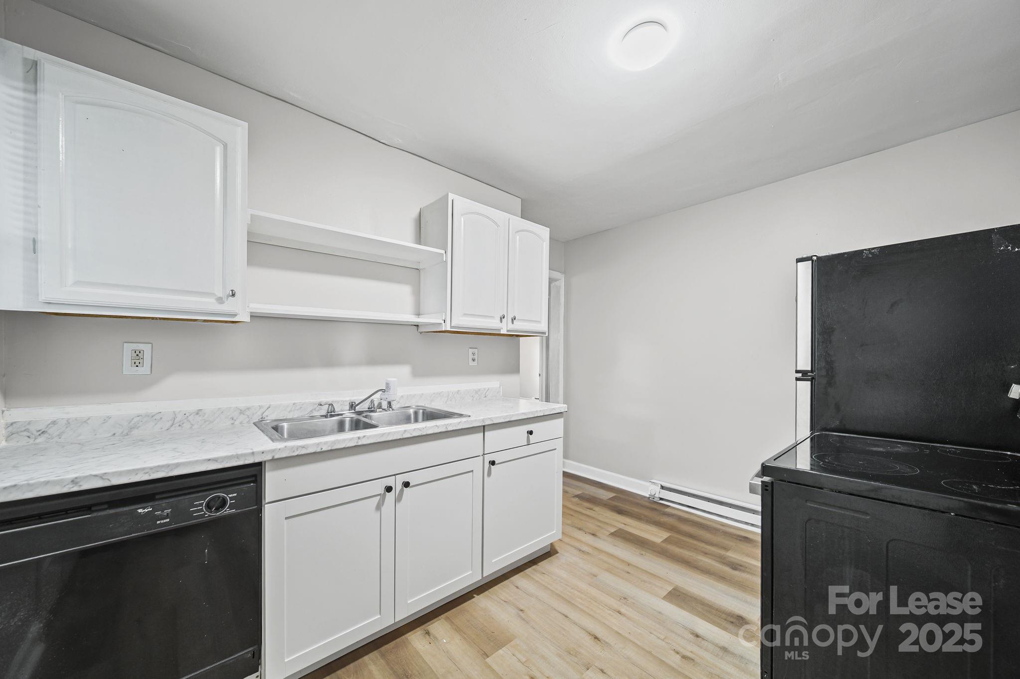 2621 Druid Hls Way, Unit 4 Charlotte, NC 28206 - Photo 15 of 35 a kitchen with a sink and cabinets