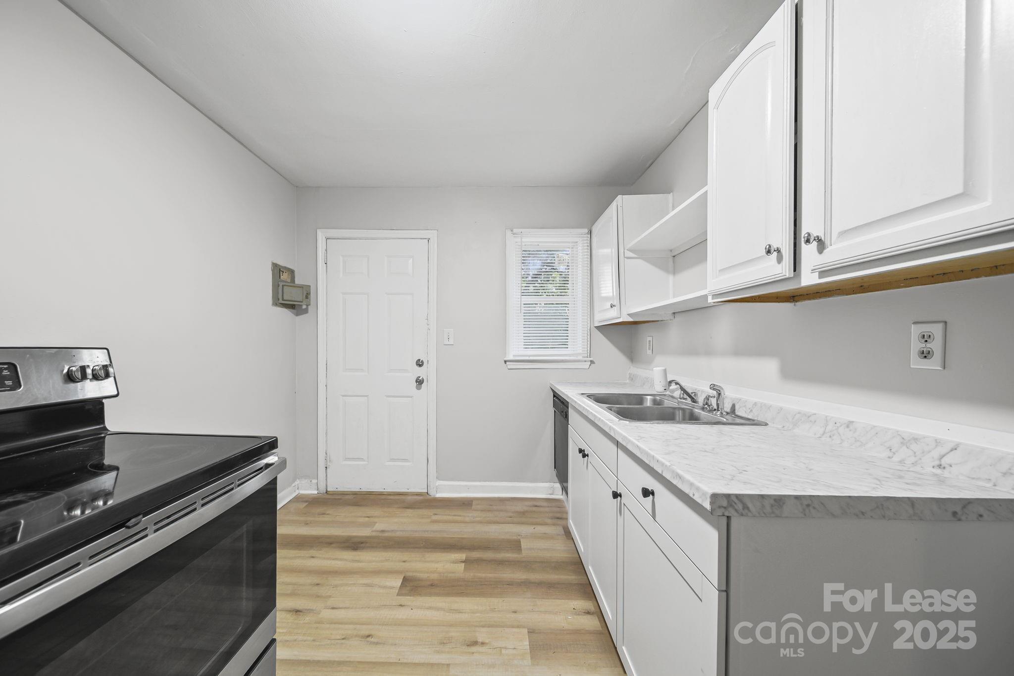 2621 Druid Hls Way, Unit 4 Charlotte, NC 28206 - Photo 17 of 35 a kitchen with a stove and a sink