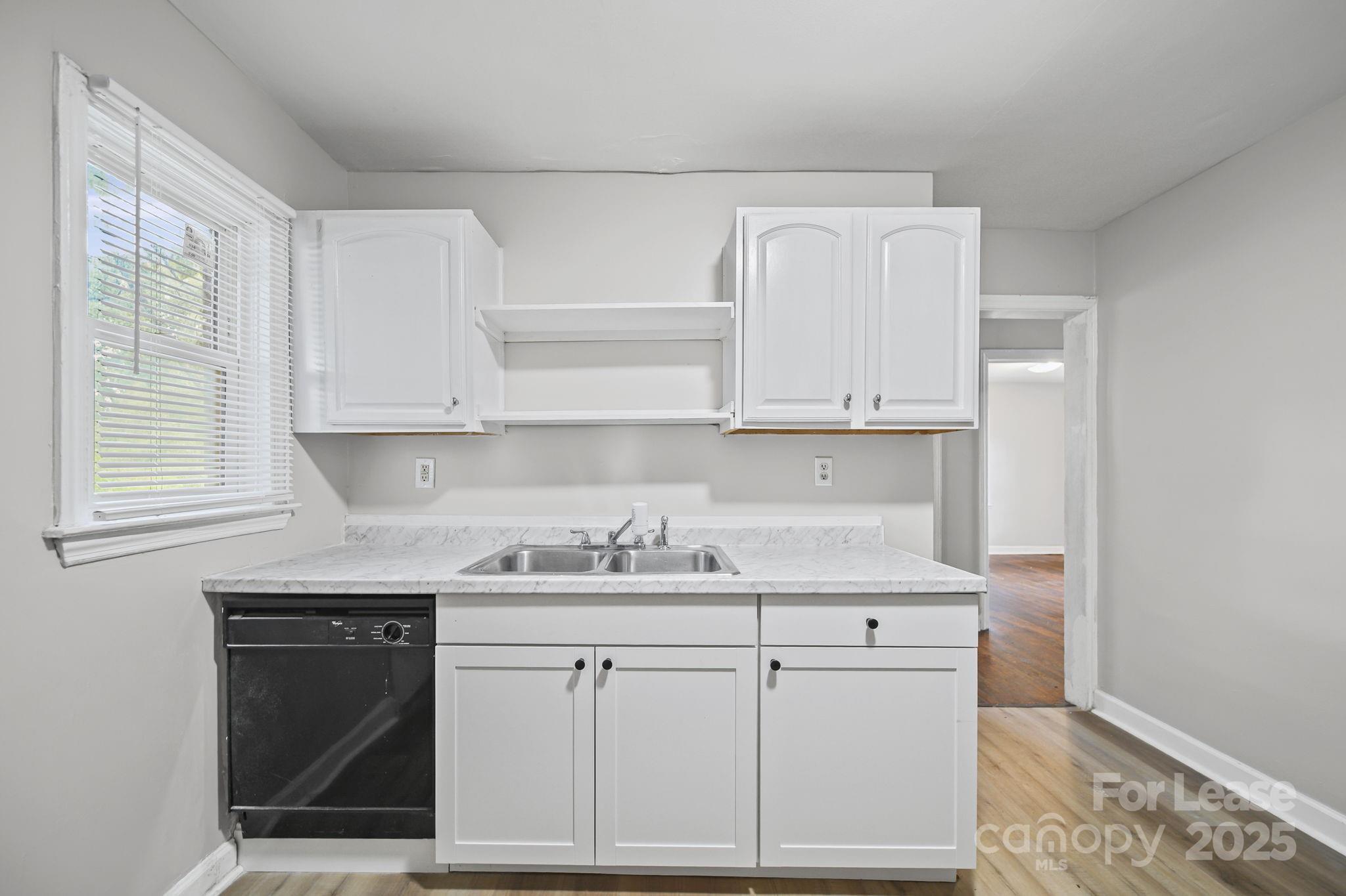 2621 Druid Hls Way, Unit 4 Charlotte, NC 28206 - Photo 18 of 35 a kitchen with white cabinets and sink