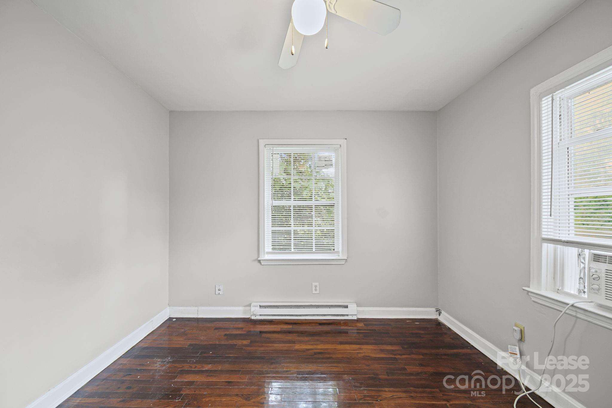 2621 Druid Hls Way, Unit 4 Charlotte, NC 28206 - Photo 23 of 35 a view of an empty room with wooden floor and a window