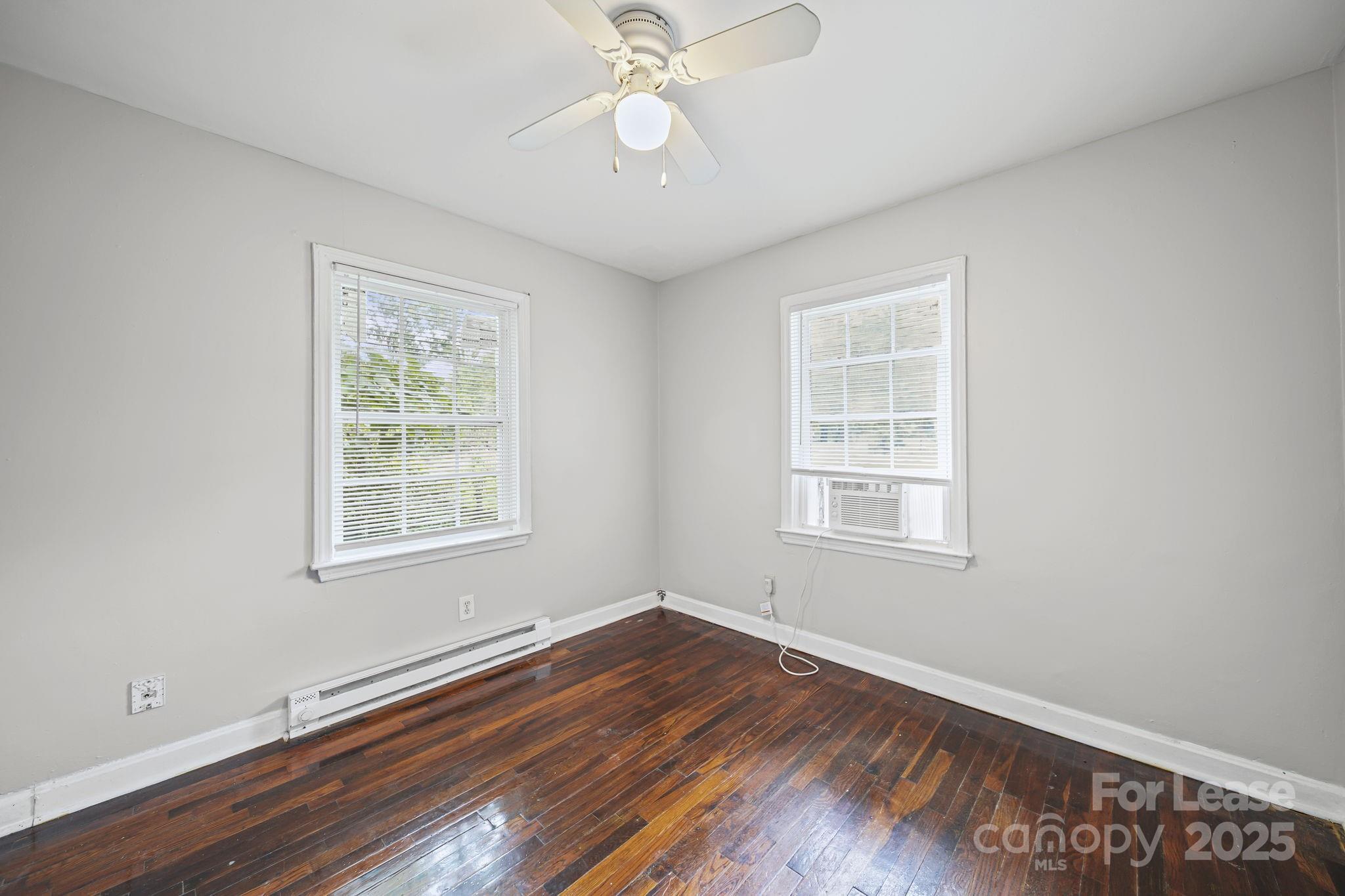 2621 Druid Hls Way, Unit 4 Charlotte, NC 28206 - Photo 24 of 35 a view of an empty room with wooden floor and a window