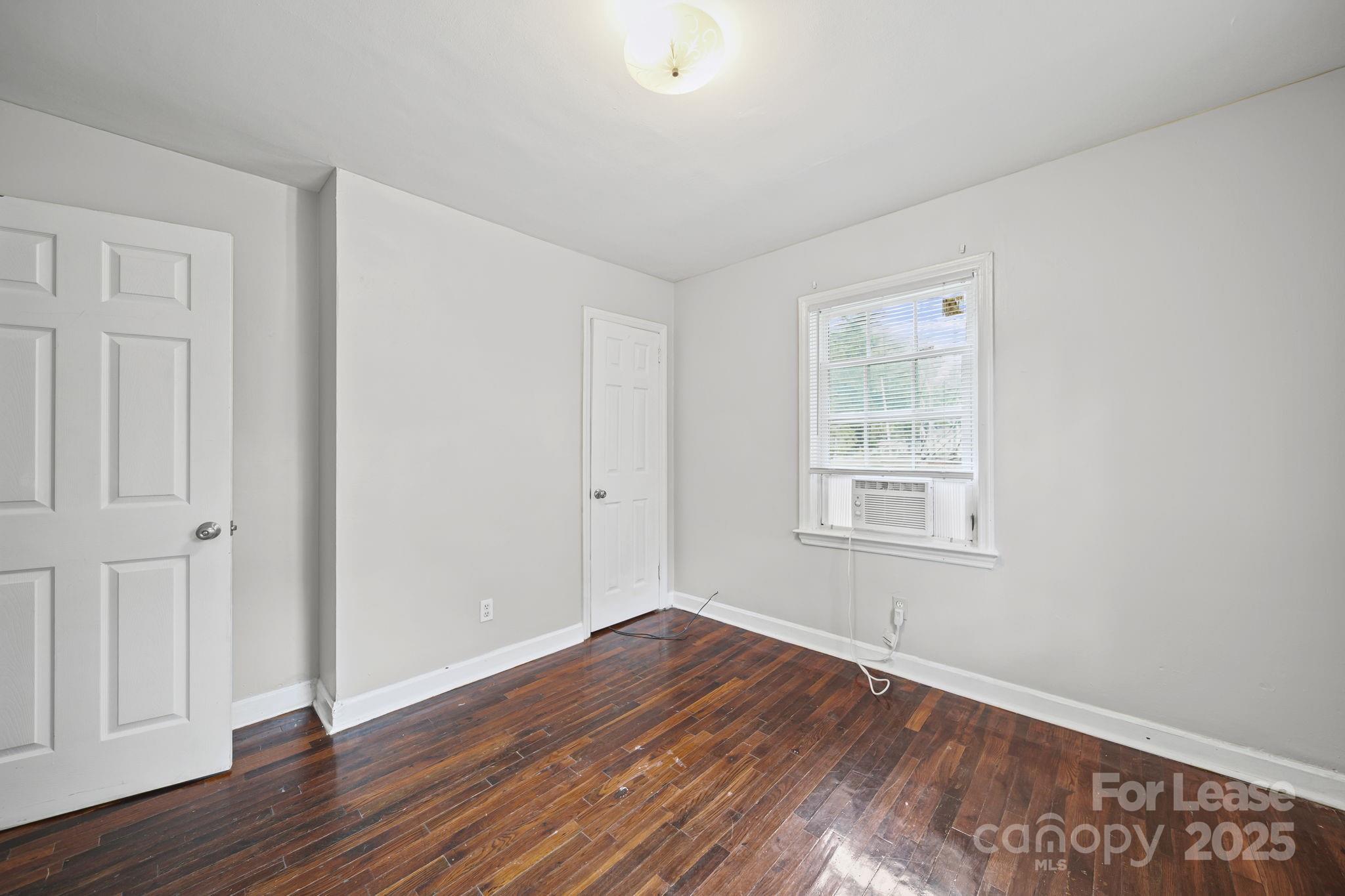 2621 Druid Hls Way, Unit 4 Charlotte, NC 28206 - Photo 25 of 35 an empty room with wooden floor and windows