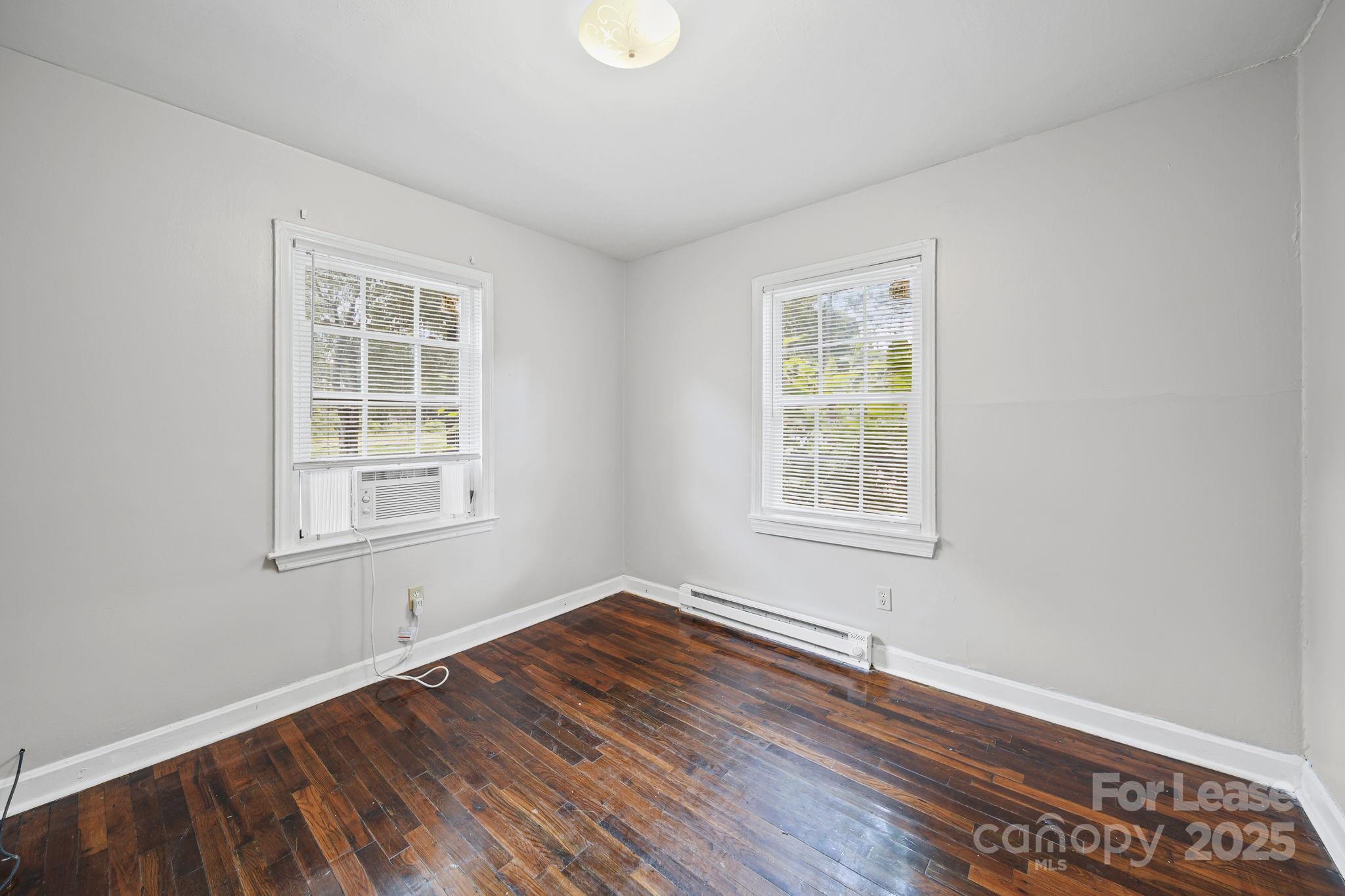 2621 Druid Hls Way, Unit 4 Charlotte, NC 28206 - Photo 29 of 35 a view of an empty room with wooden floor and a window