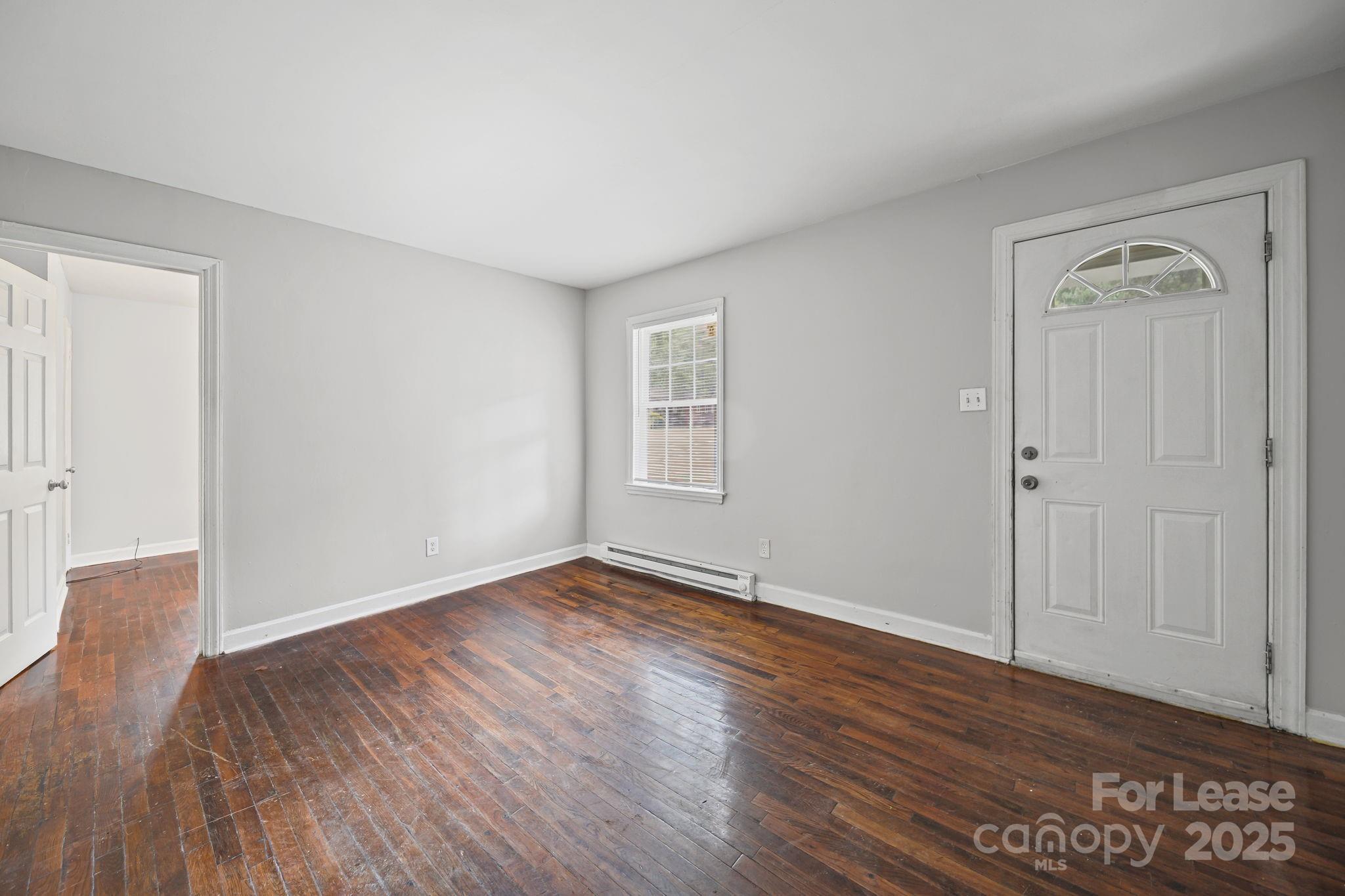 2621 Druid Hls Way, Unit 4 Charlotte, NC 28206 - Photo 31 of 35 a view of an empty room with wooden floor and a window