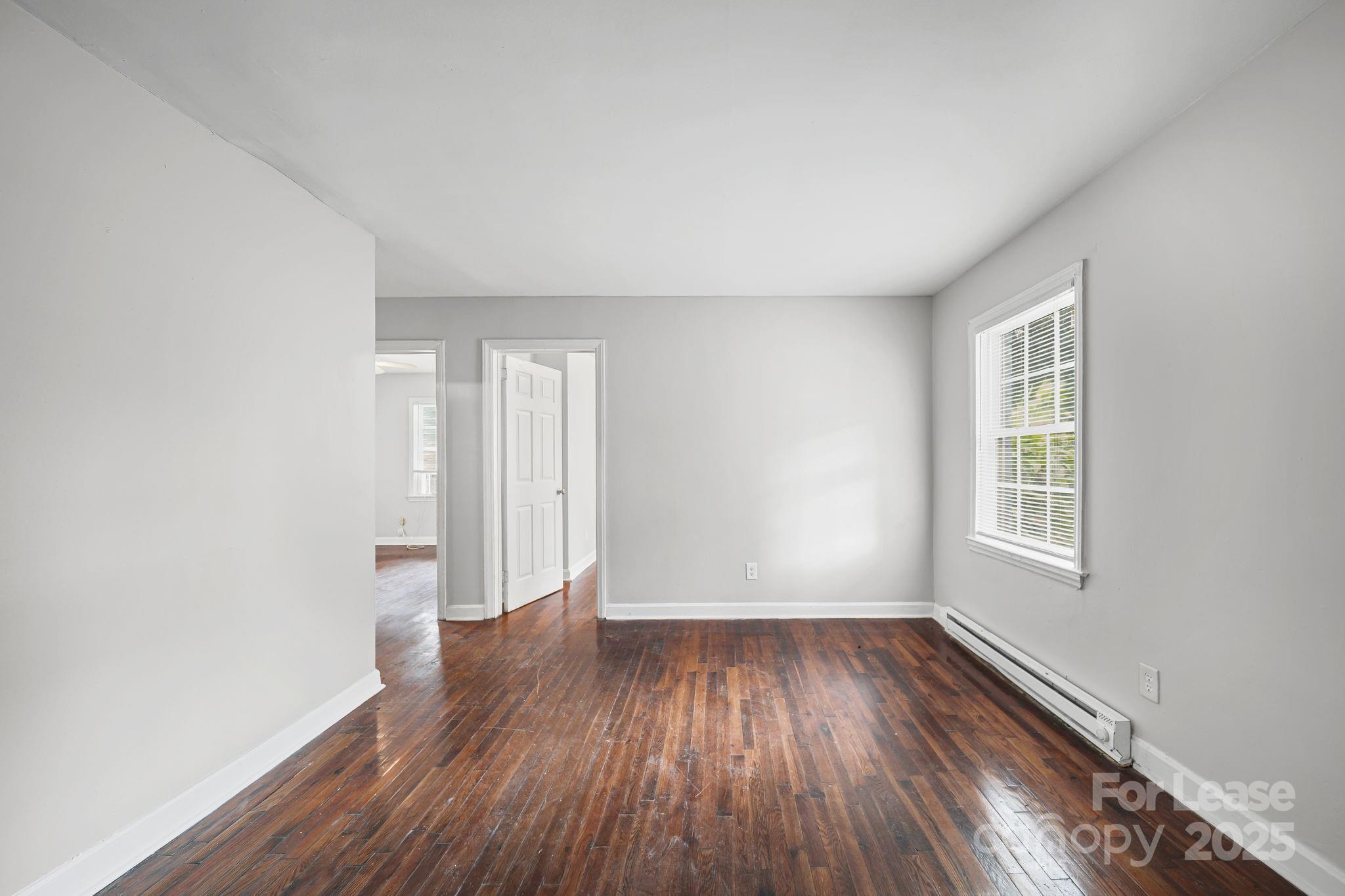 2621 Druid Hls Way, Unit 4 Charlotte, NC 28206 - Photo 32 of 35 an empty room with wooden floor and windows