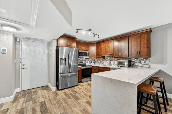a kitchen with stainless steel appliances a refrigerator and a stove top oven