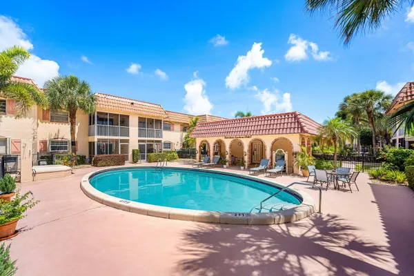 a view of a swimming pool with a patio and plants