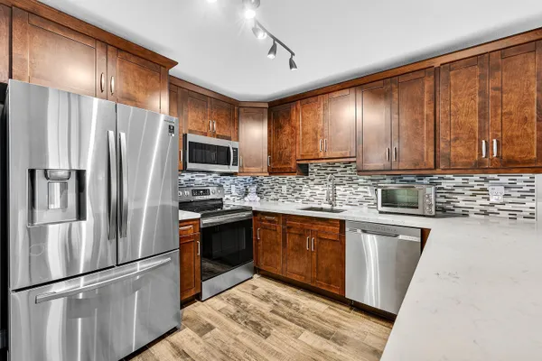 a kitchen with granite countertop stainless steel appliances and wooden cabinets
