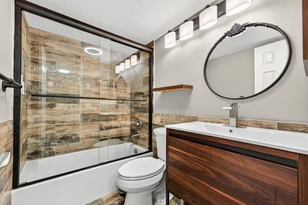 a bathroom with a sink mirror toilet and shower