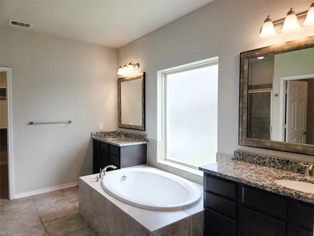 a bathroom with a double vanity sink mirror and toilet