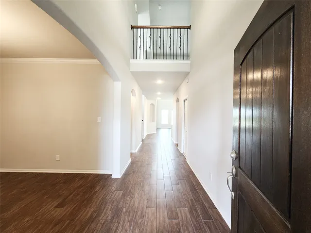 a view of a hallway with wooden floor and staircase