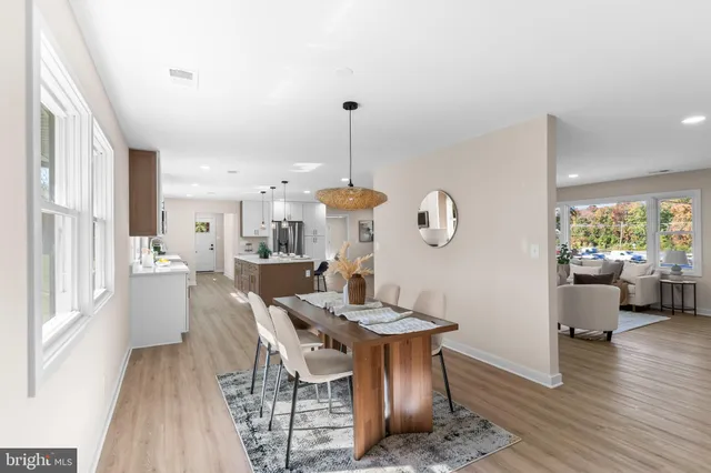 a dining room with furniture a chandelier and wooden floor