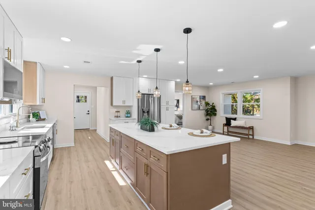 a kitchen with stainless steel appliances kitchen island granite countertop a sink stove and wooden floor