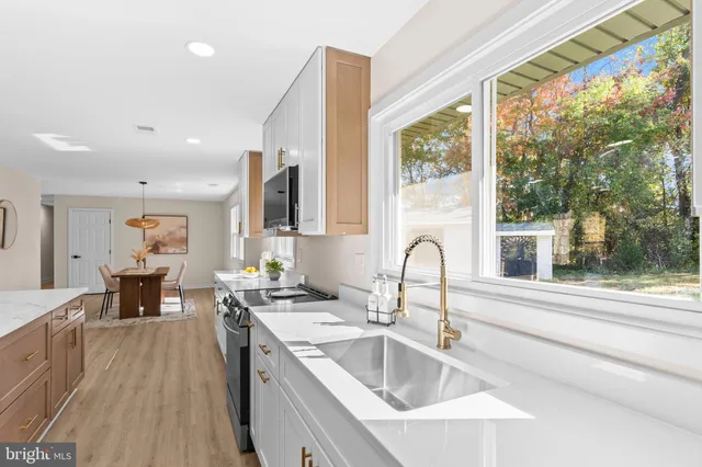 a kitchen with a sink wooden floor and a large window