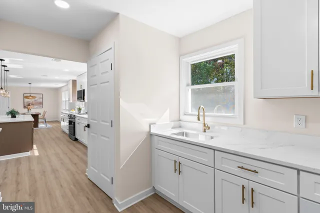 a spacious bathroom with a sink a mirror and next to a window