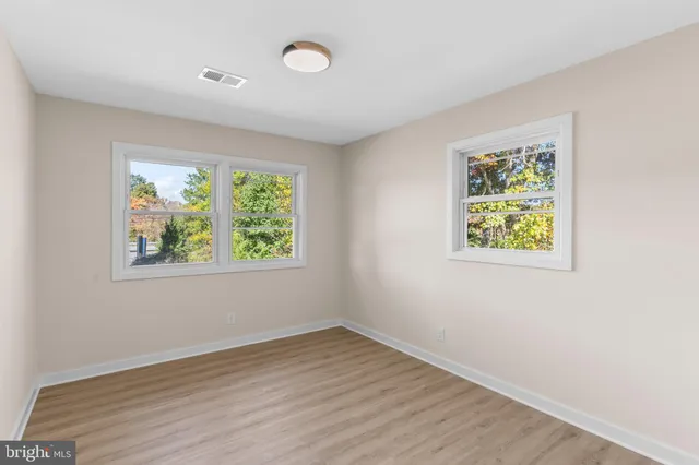 an empty room with wooden floor and window