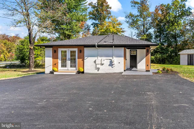 a view of a house with backyard and a tree