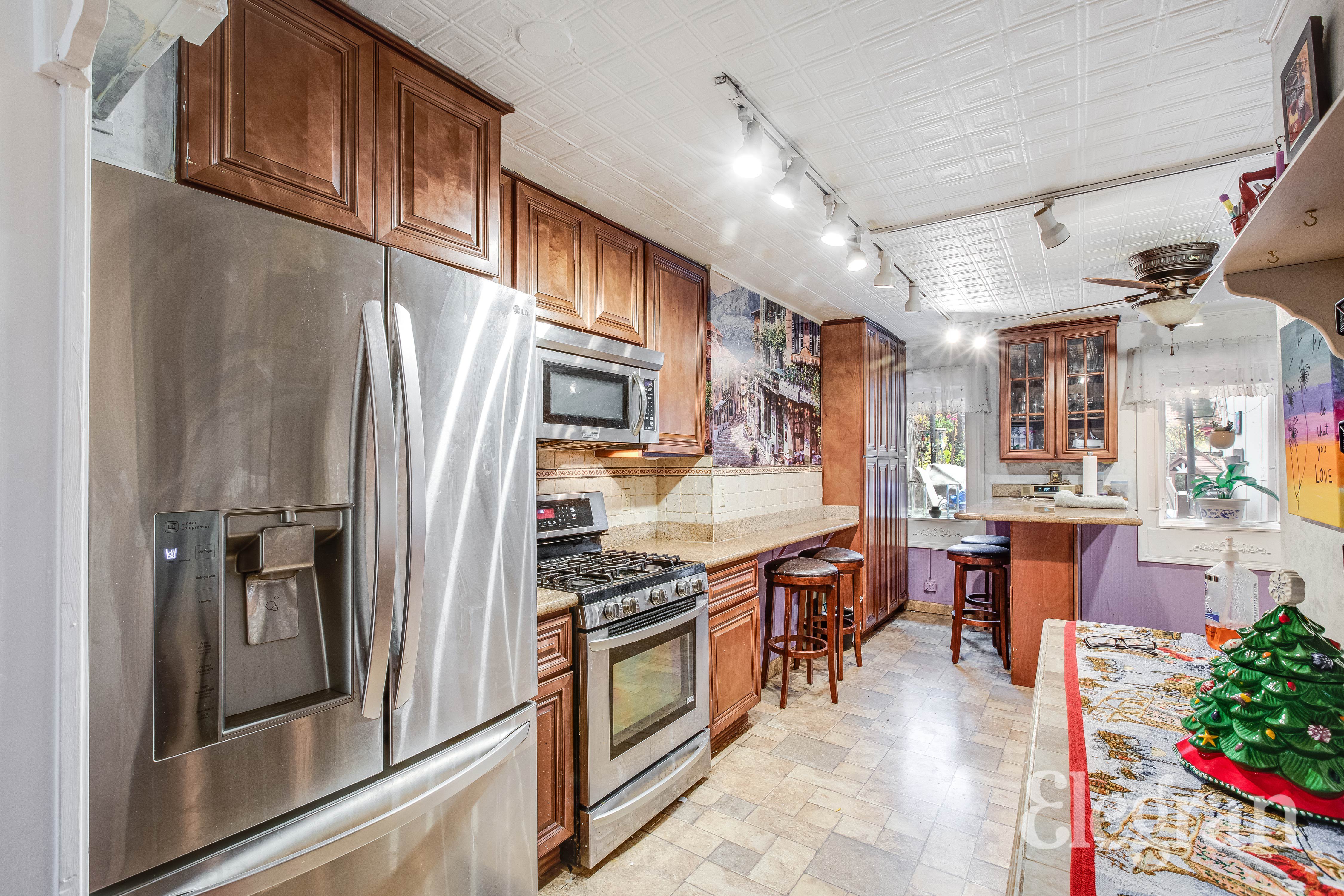 a kitchen with stainless steel appliances granite countertop a refrigerator a sink dishwasher a stove and a dining table with wooden floor