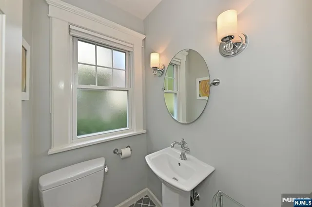 a bathroom with a toilet a sink and mirror