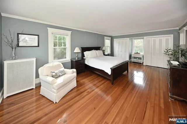 a spacious bedroom with a bed and wooden floor