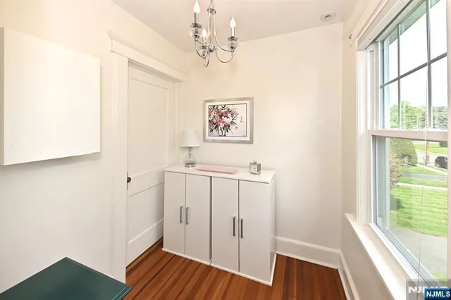a view of a hallway with a window and wooden floor