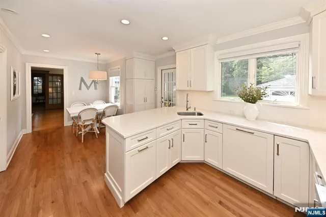 a kitchen with a sink wooden floor and windows