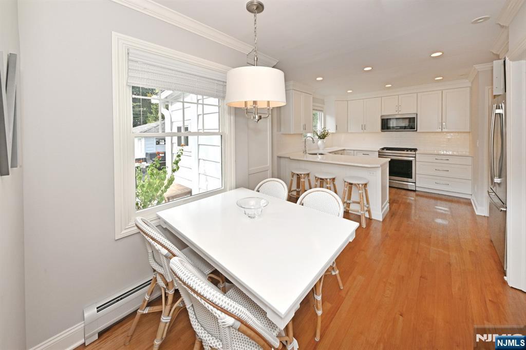 18 Tonawanda Road Glen Rock, NJ 07452 - Photo 10 of 37 a large white kitchen with a stove a sink a refrigerator dining table and chairs