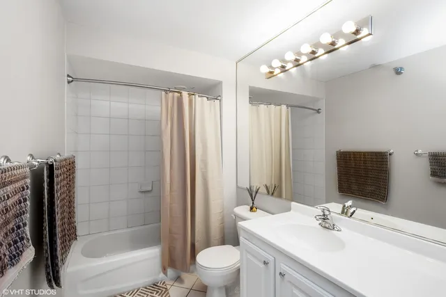 a bathroom with a sink a toilet a mirror and shower