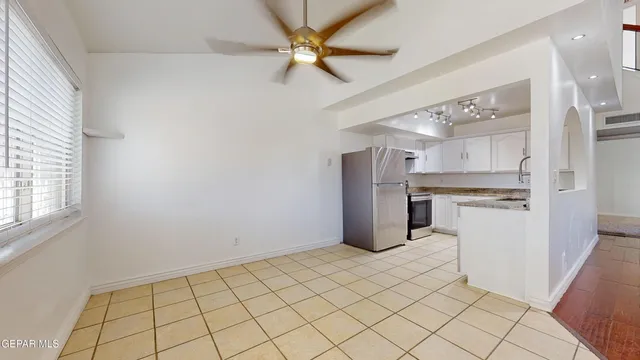 a view of a kitchen with a refrigerator and a stove top oven