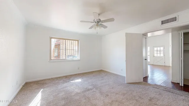 an empty room with closet and a ceiling fan