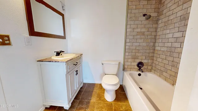 a bathroom with a granite countertop sink toilet and bathtub