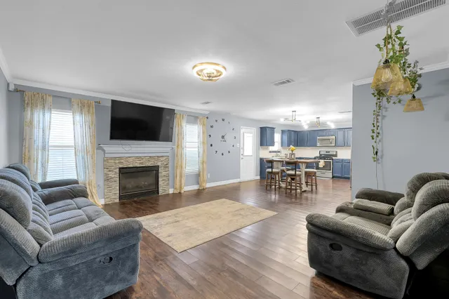 a living room with furniture a fireplace and a flat screen tv