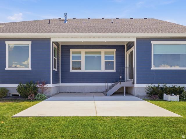 2786 West Hancock Street, Unit 198 Mapleton, UT 84664 - Photo 29 of 33 Rear exterior featuring a concrete patio, blue siding, white window trim, and a shingle roof
