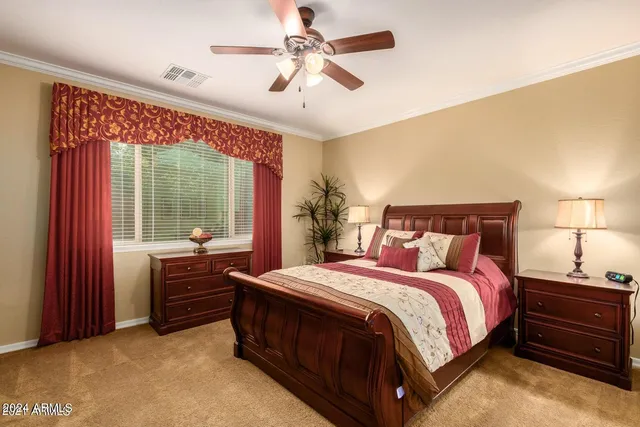 a bedroom with a bed dresser and a large window