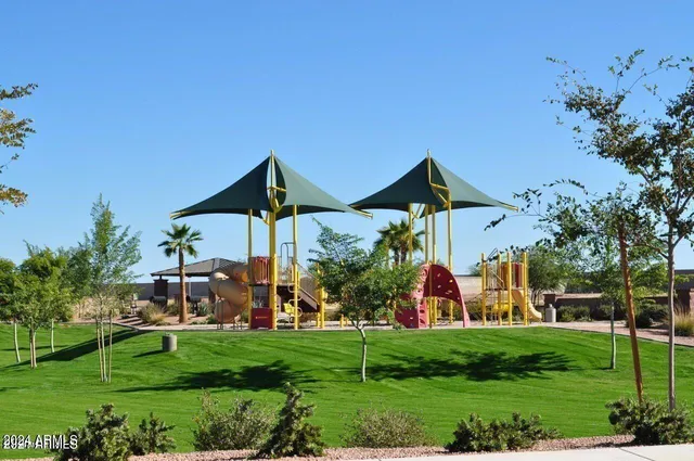 a view of a house with a yard and table and chairs under an umbrella