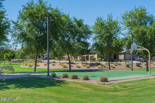 a front view of a building with garden and trees