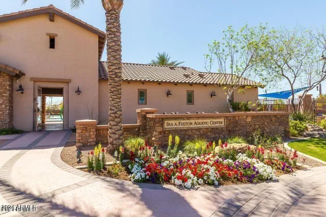 a front view of a house with a yard and a fountain