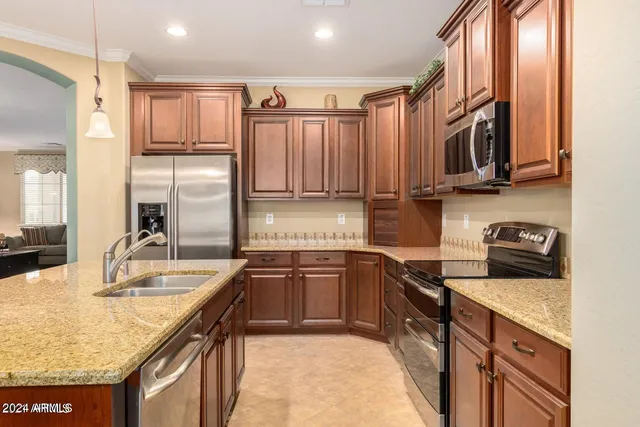 a kitchen with stainless steel appliances granite countertop a sink a stove and a refrigerator