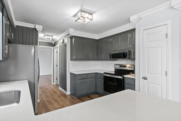 a kitchen with stainless steel appliances granite countertop a refrigerator a stove top oven a sink and dishwasher